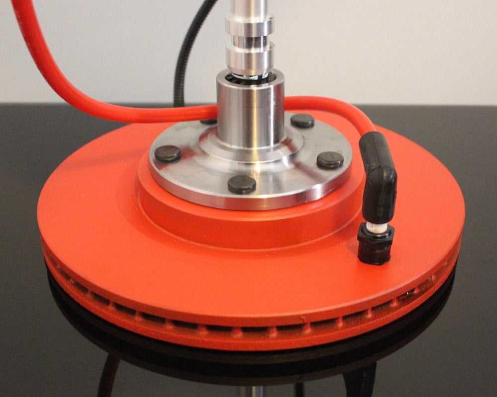 Red circular device with a metallic center on a reflective surface