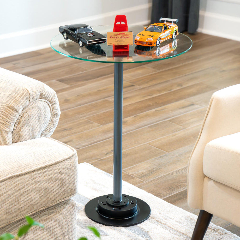 Glass side table with black metal base in a living room setting