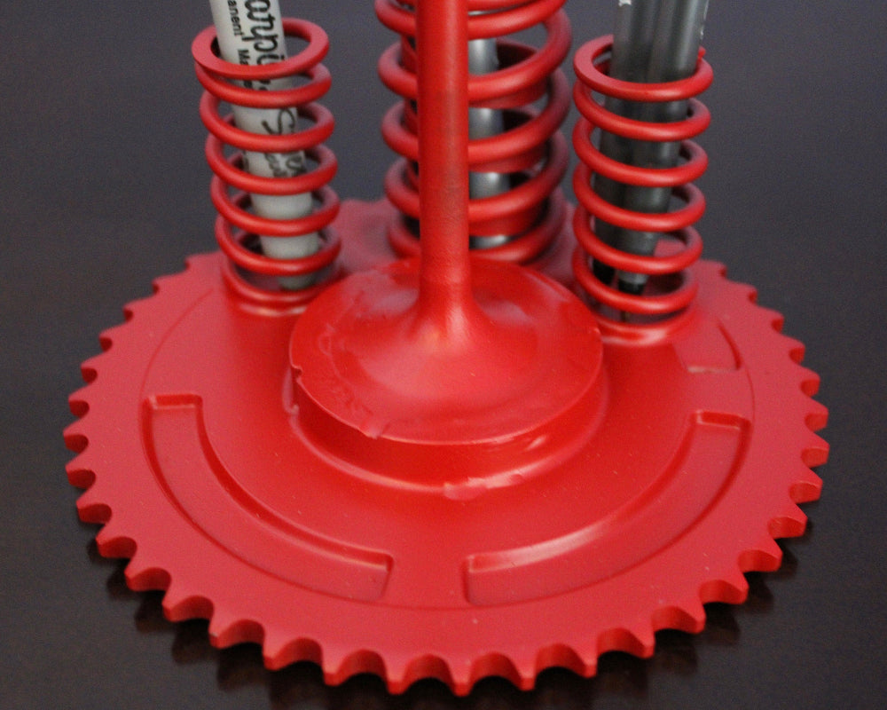 Red mechanical device with springs and gears on a black background