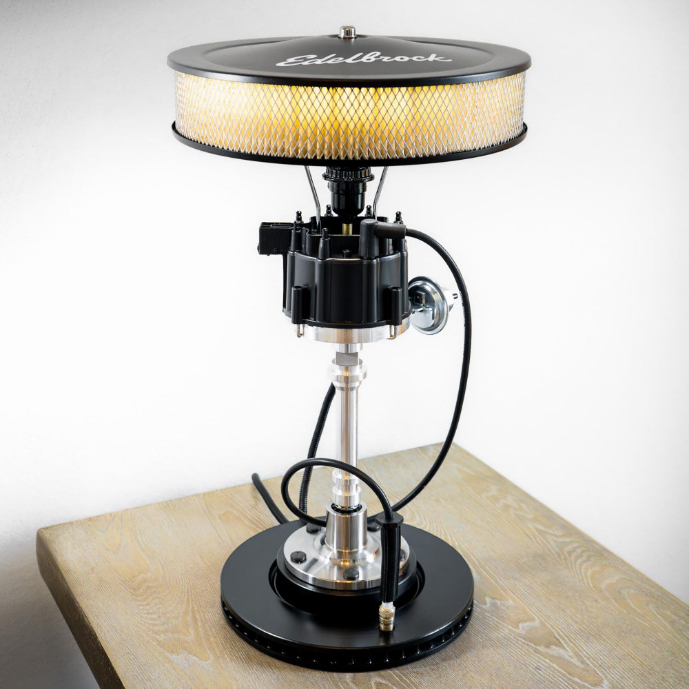 Vintage-style lamp with a metallic base and round shade on a wooden surface.