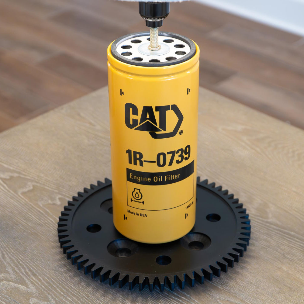 Yellow CAT engine oil filter on a wooden surface