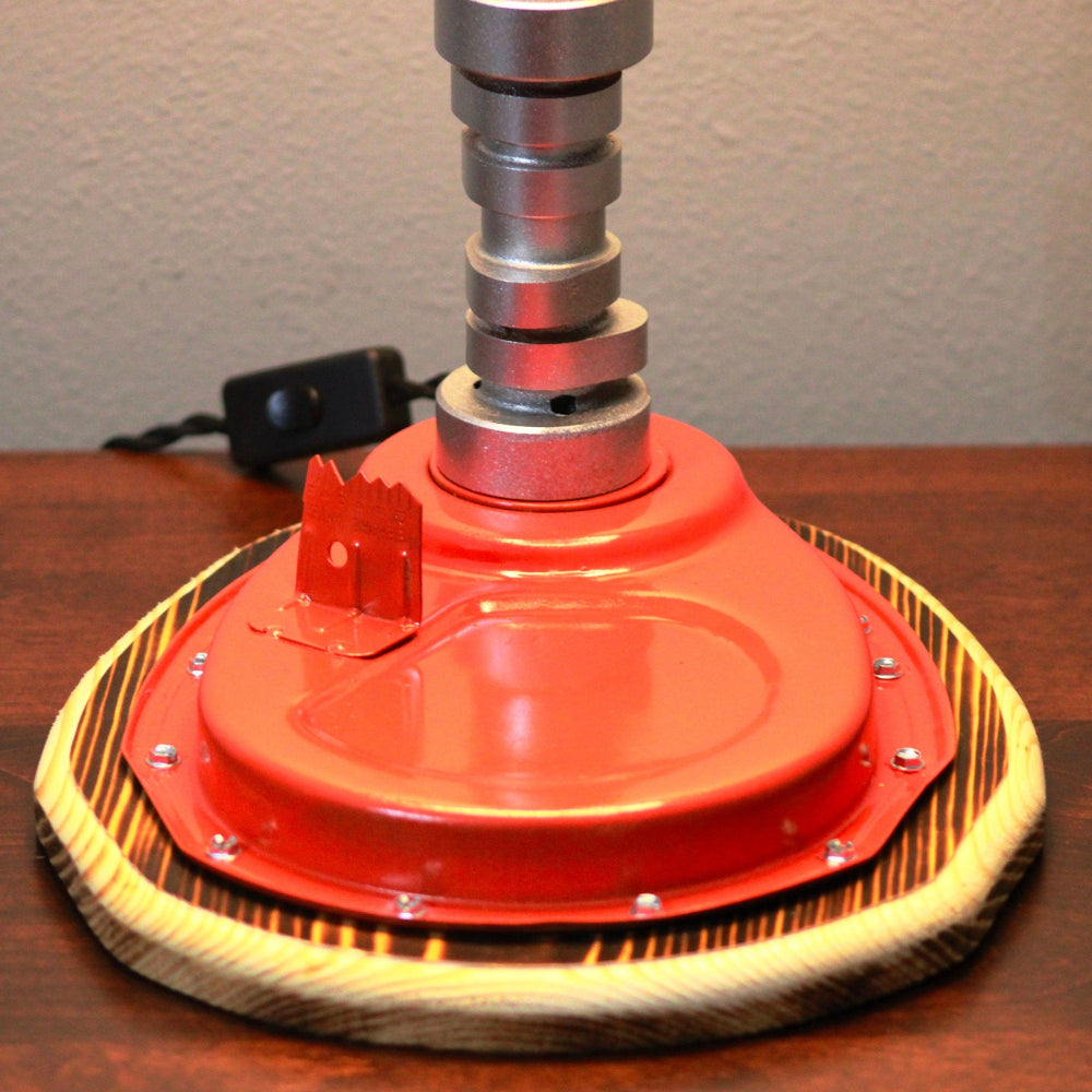 Red floor buffer on a wooden surface with a neutral background