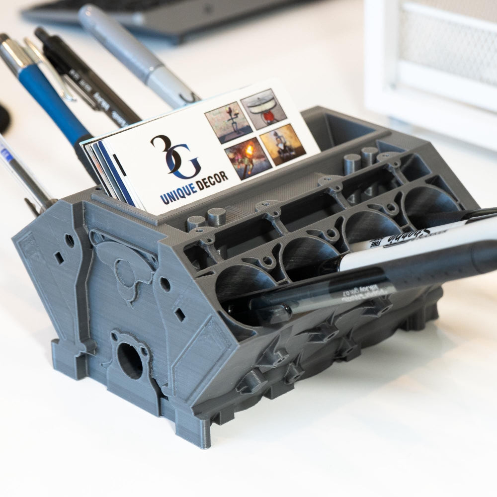 Gray pen holder with stationery items on a white surface