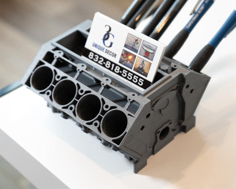 Engine block with a business card on top on a white surface