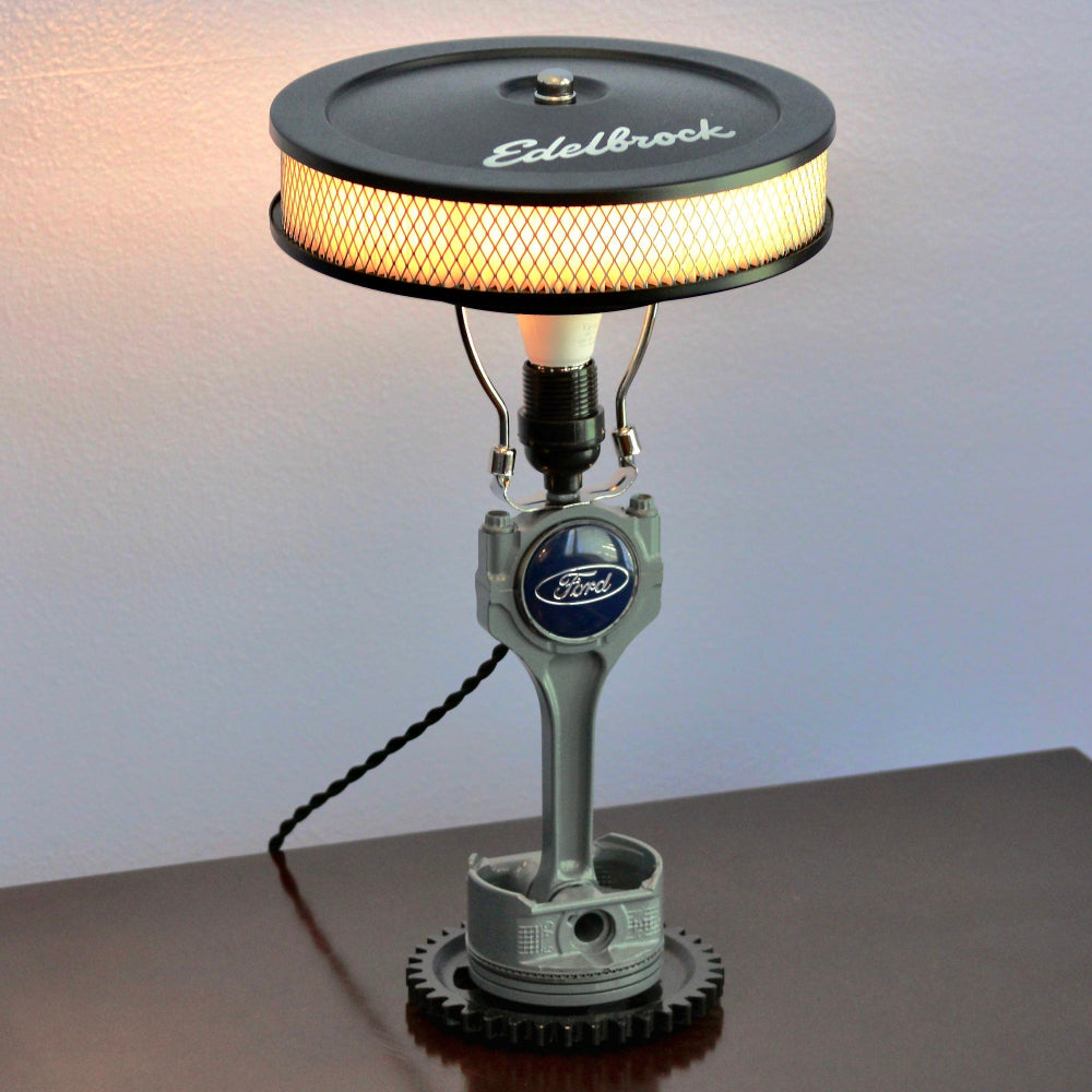 Lamp made from a vintage engine component on a white background