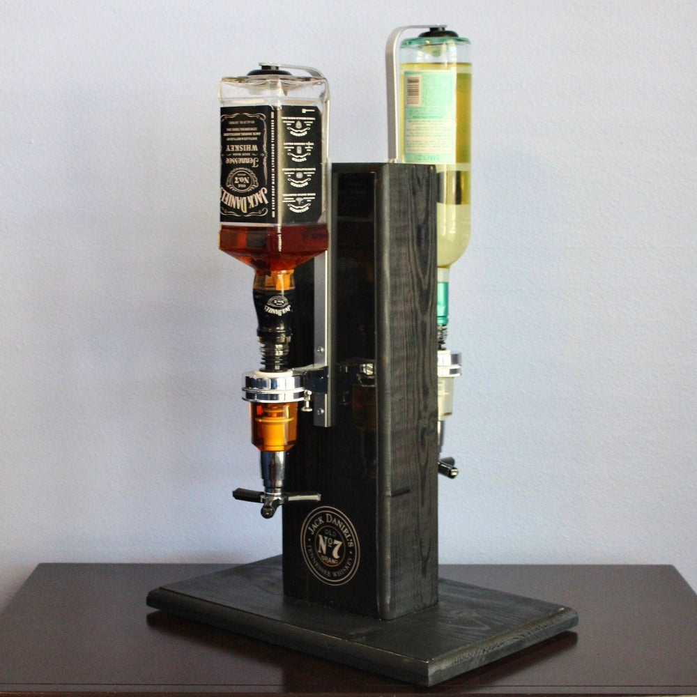 Beverage dispenser with three bottles on a wooden surface against a gray background