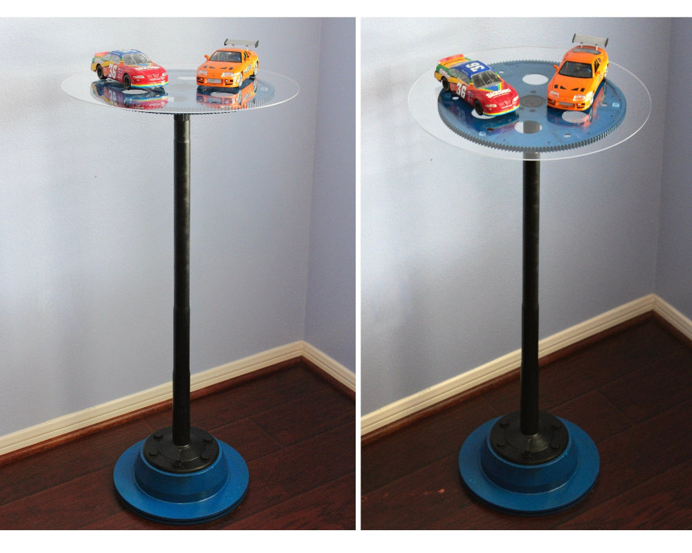 Glass table with toy cars on a plain background