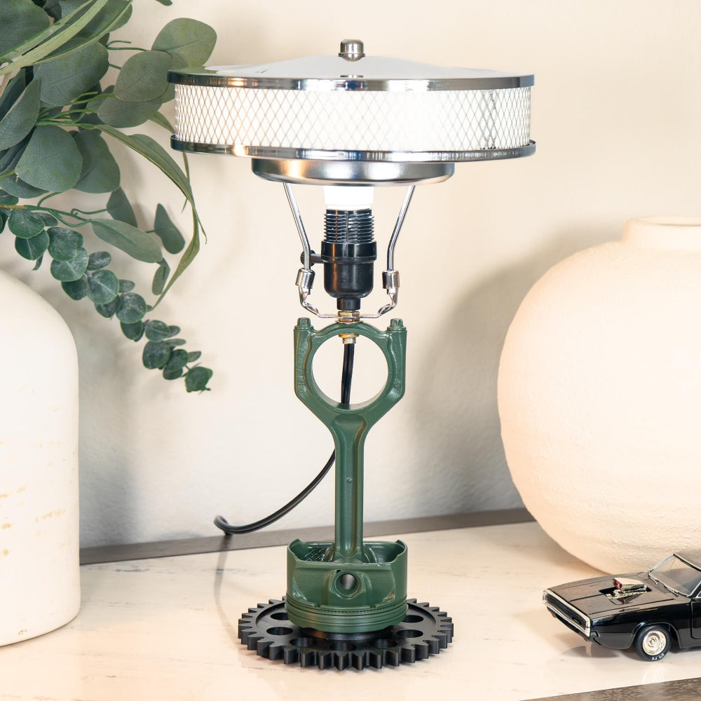 Decorative lamp with a unique design on a surface next to a plant and a model car.