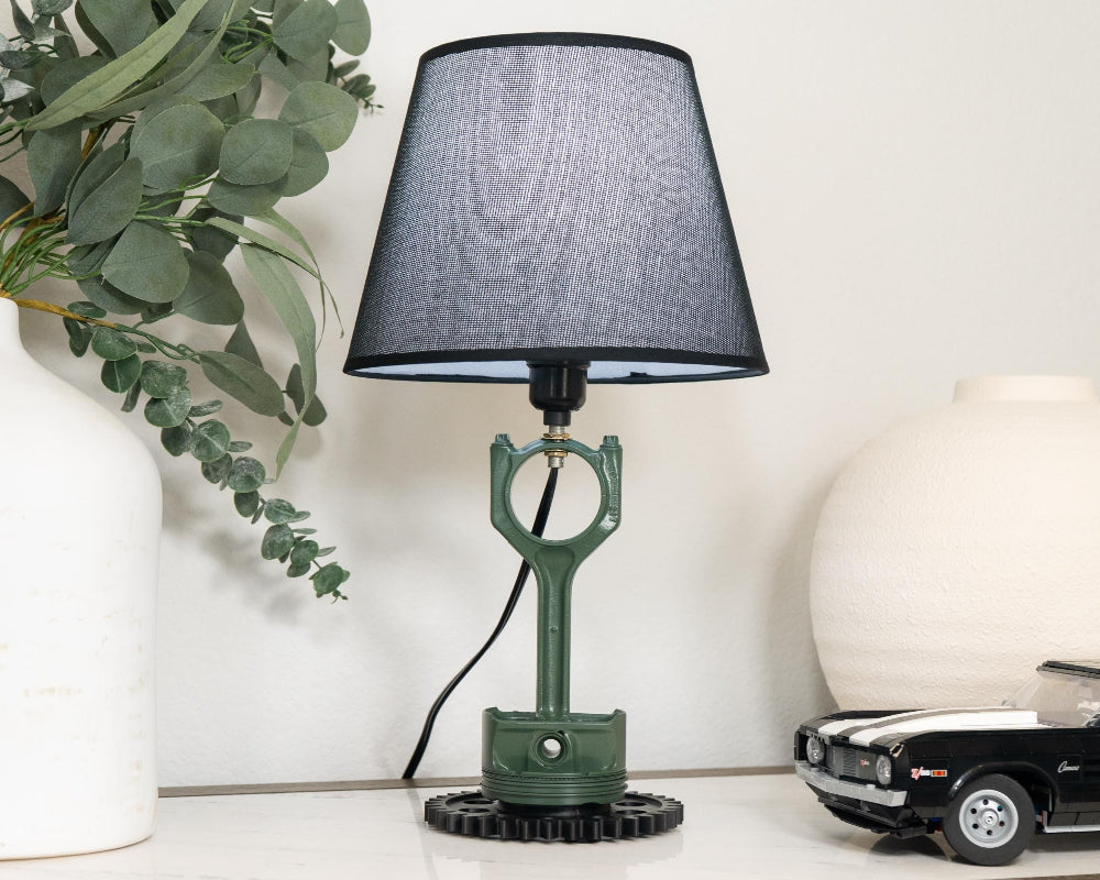Table lamp with black shade on a surface with decorative items