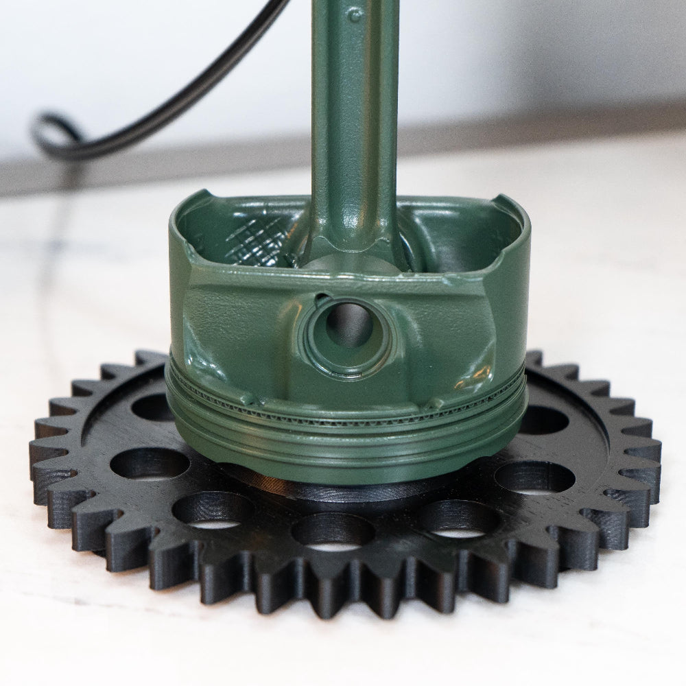 Green mechanical component with a black gear on a white background
