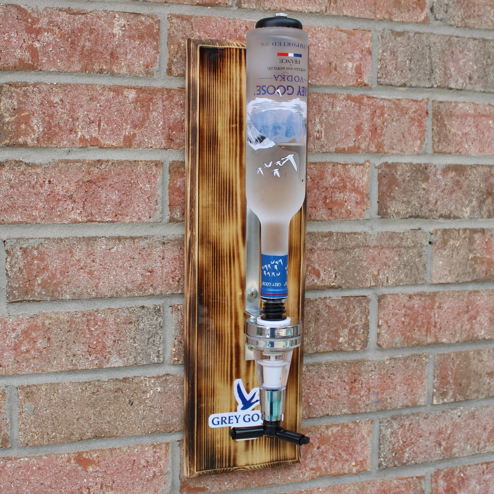 Wooden bottle holder with a bottle against a brick wall