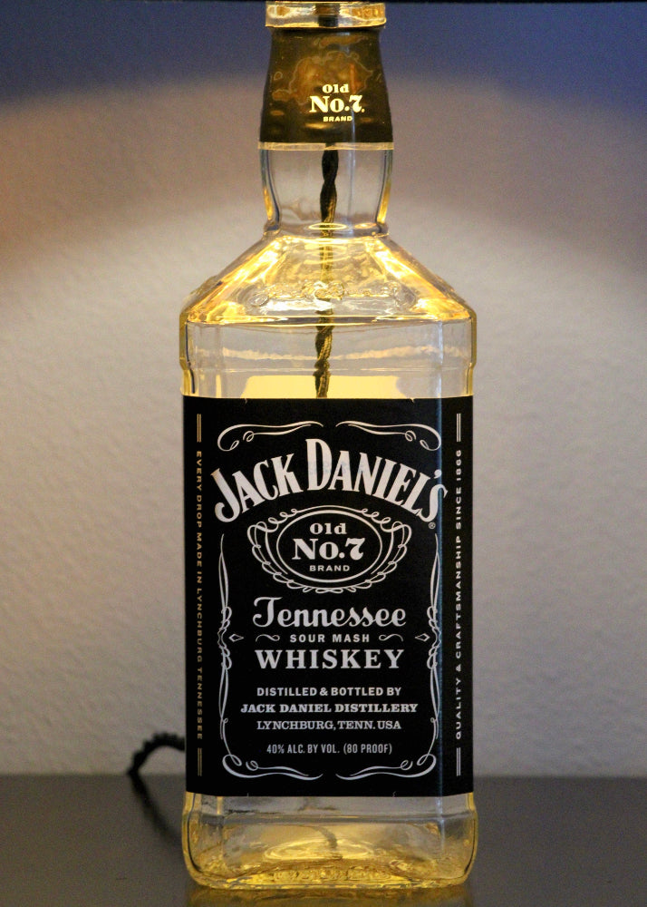 Jack Daniel's Tennessee Whiskey bottle lamp on a reflective surface with a neutral background