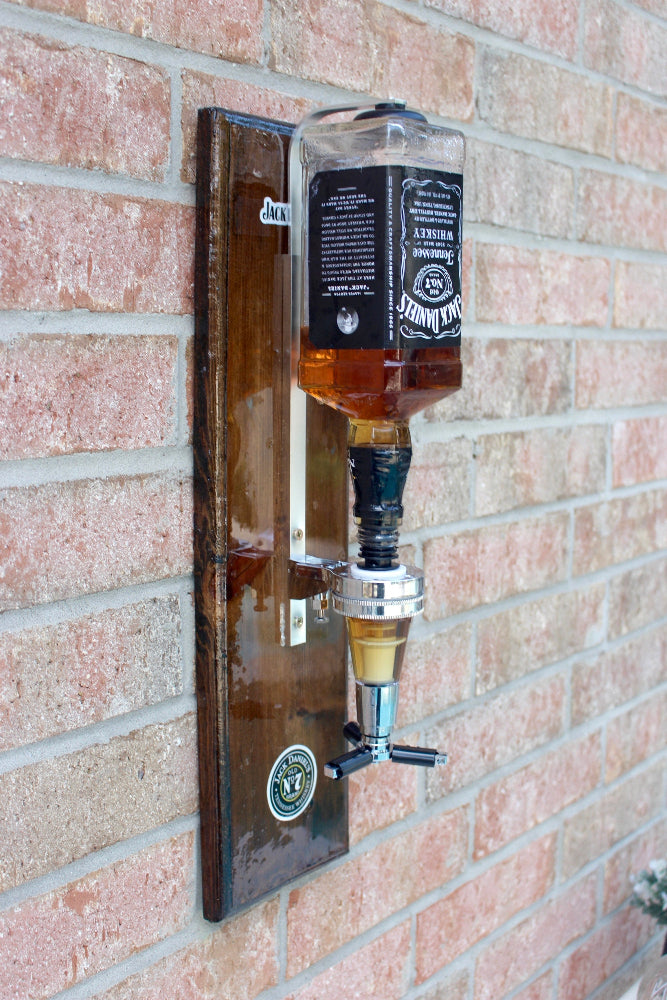 Wall-mounted Jack Daniel's whiskey dispenser on a brick wall