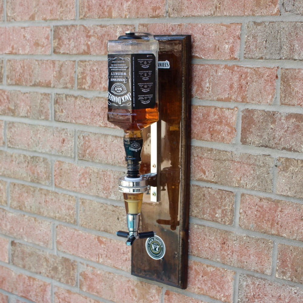 Wall-mounted bottle of Jack Daniel's Tennessee Whiskey against a brick wall.
