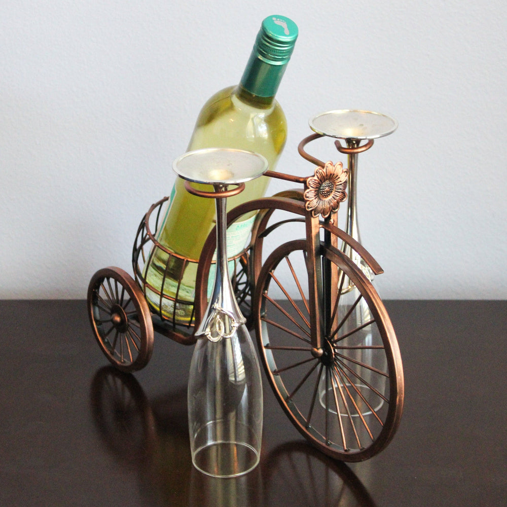 Wine bottle and glass holder shaped like a bicycle on a dark surface with a white background