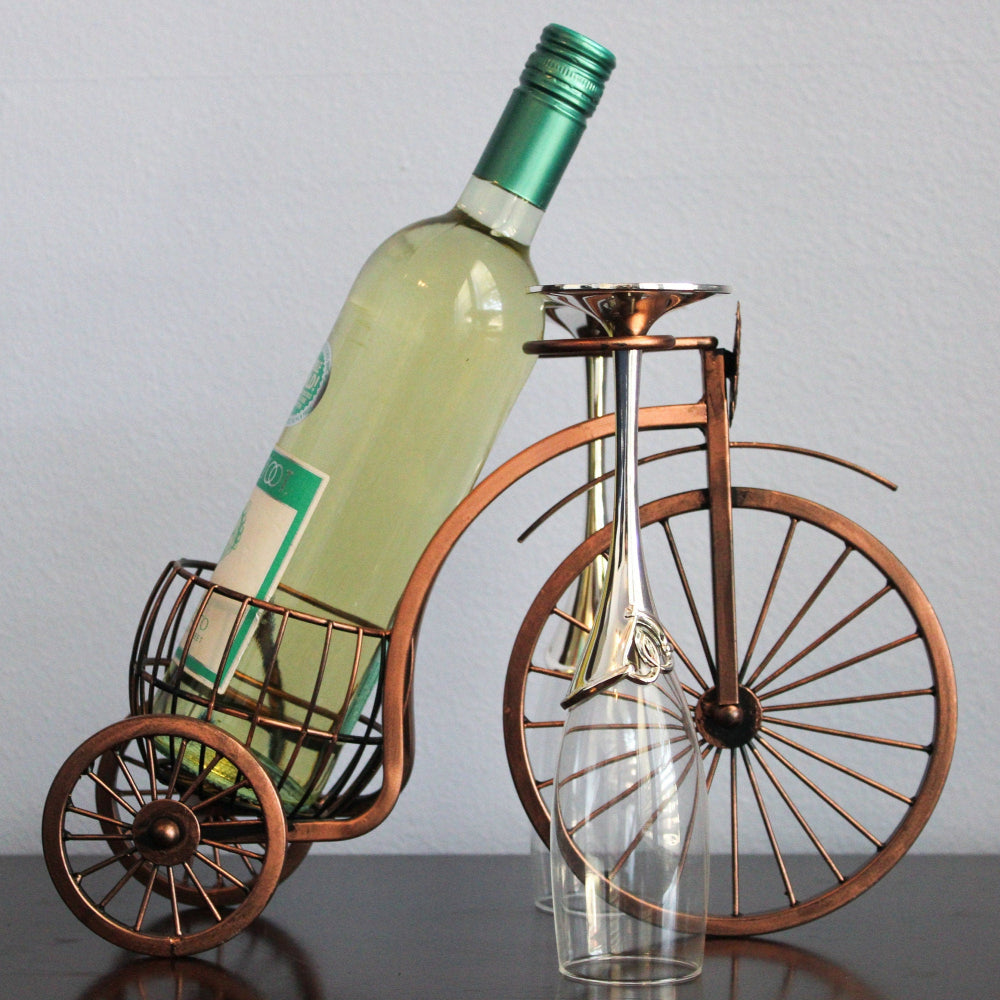 Wine bottle and glass holder shaped like a vintage bicycle on a plain background