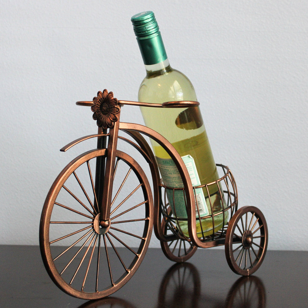 Bicycle-shaped wine bottle holder with a bottle of white wine on a plain background