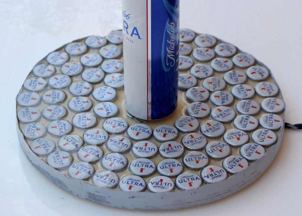 Michelob Ultra beer can on a coaster made of bottle caps with a white background