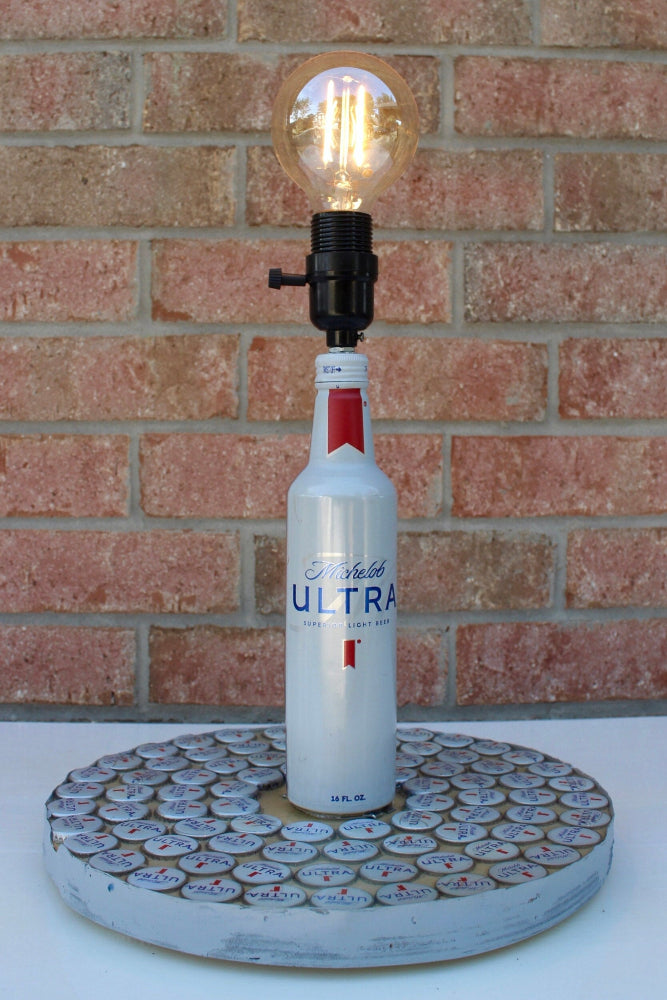 Lamp made from a Prohibition Ultra bottle against a brick wall.