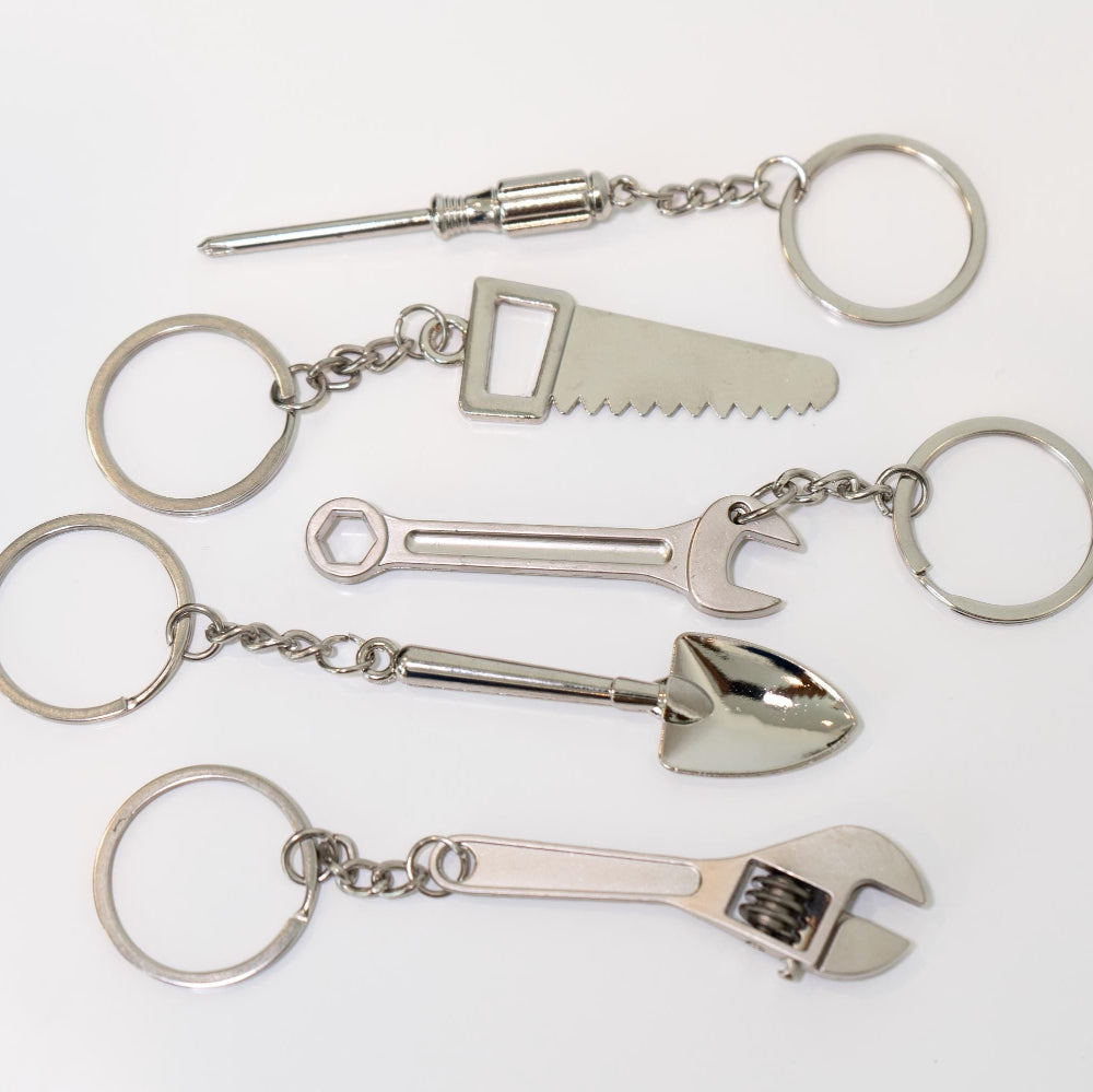 Set of metal keychains shaped like tools on a white background