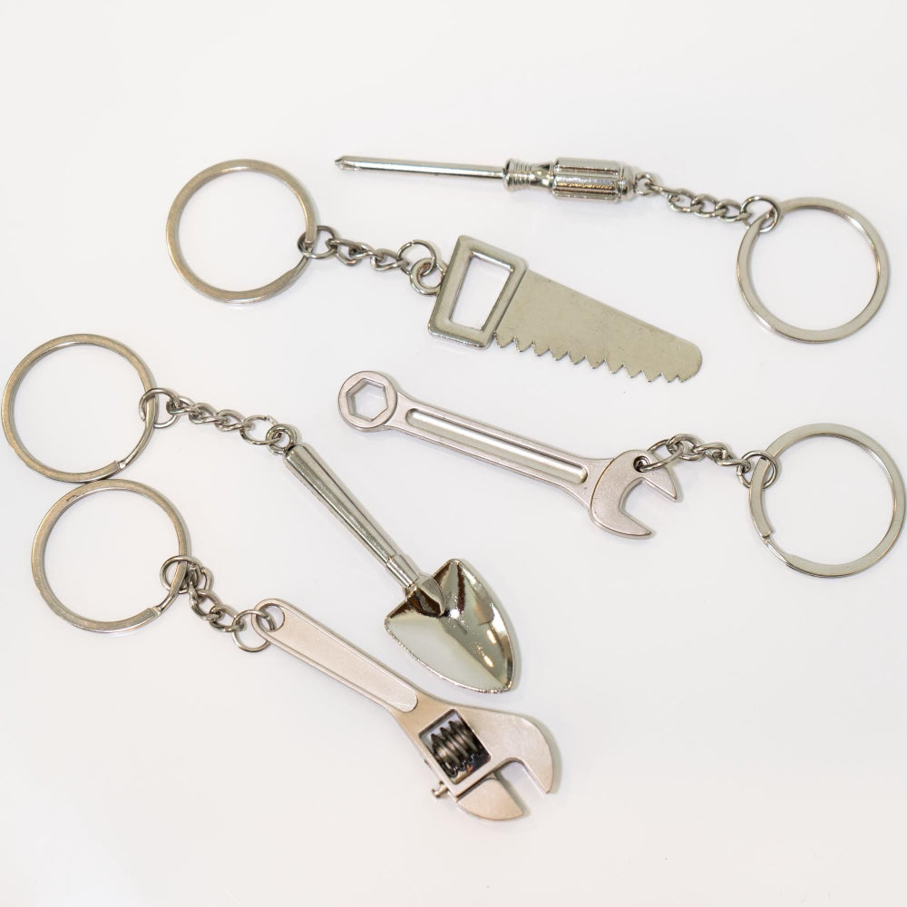 Set of keychains with tool-shaped charms on a white background