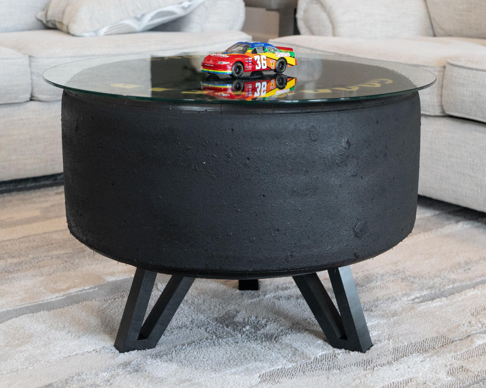 Round black coffee table with a glass top in a living room setting