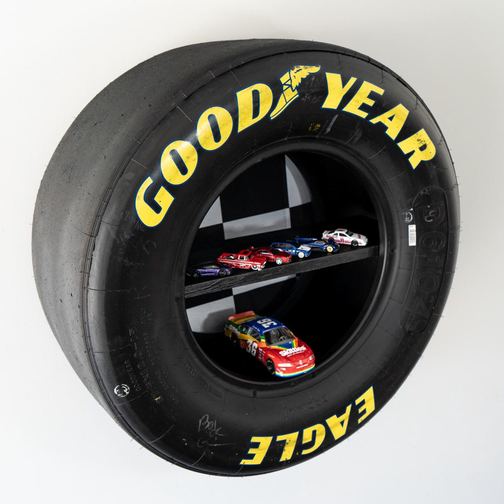Goodyear tire with toy cars inside on a white background