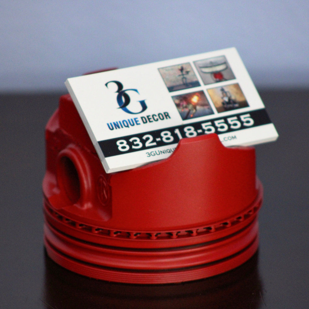 Red decorative item with a business card on a dark surface