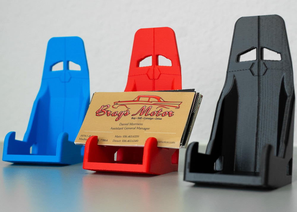 Three colorful business card holders on a gray surface with a white background