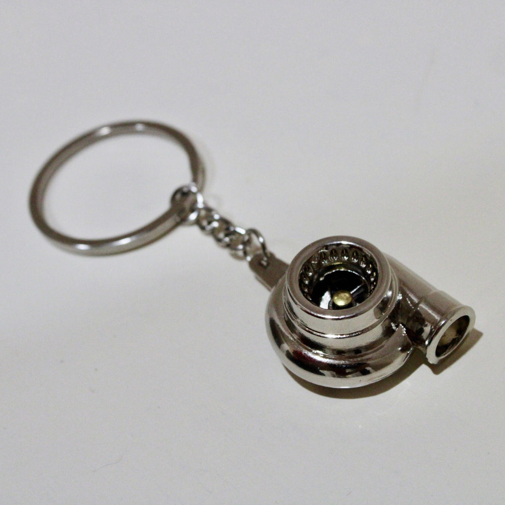 Metallic turbocharger keychain on a white background