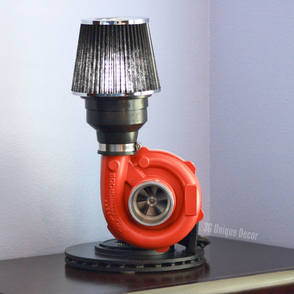 Red turbocharger shaped like a lamp on a gray surface with a light gray background