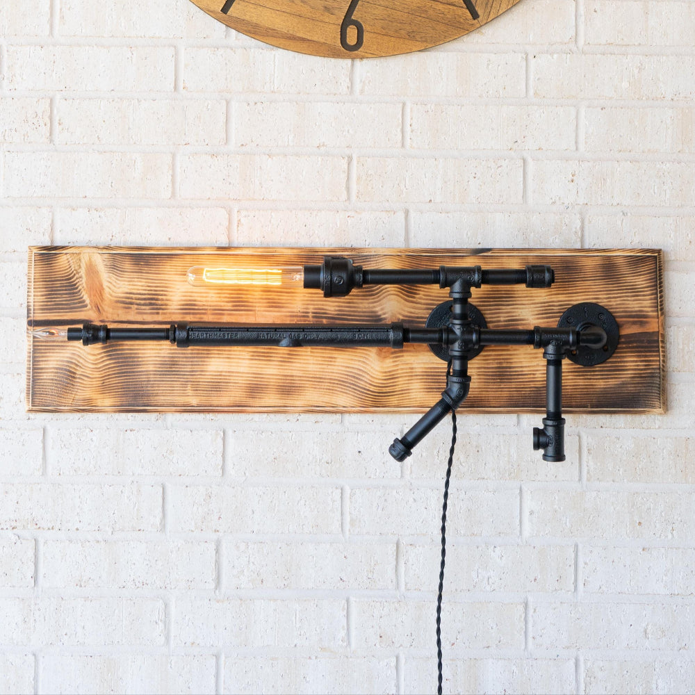 Wooden wall clock and decorative light fixture on a white brick wall.