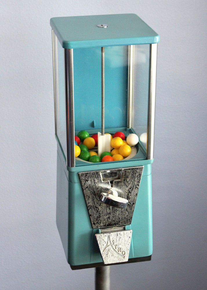 Teal gumball machine with colorful gumballs on a gray background