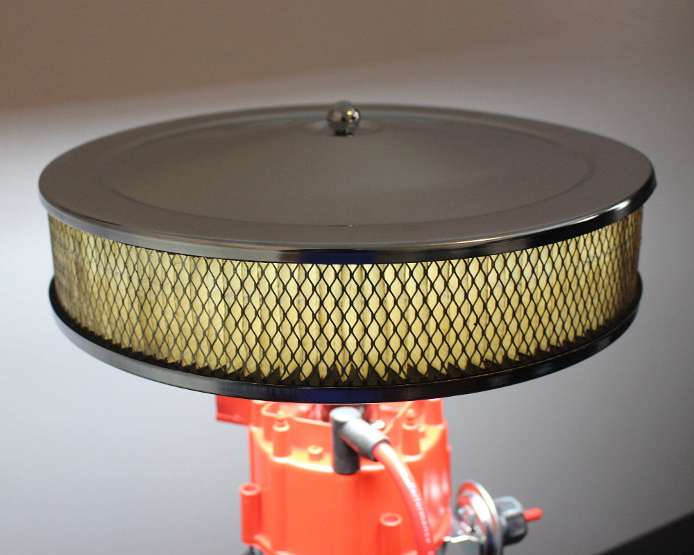 Round air filter on a red mechanical component with a gray background
