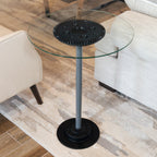 Glass side table with black gear design in a living room setting