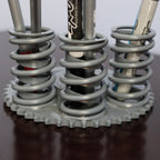 Pencil holder made from metal springs on a dark surface with a white background