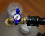 Brass valve with blue handle on a blurred background