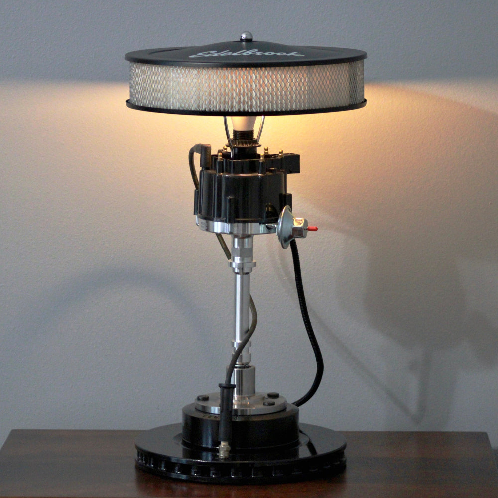 Table lamp with unique design on a wooden surface against a plain wall