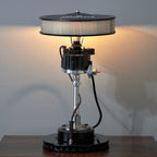 Table lamp with unique design on a wooden surface against a plain wall