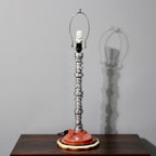 Table lamp with unique design on a wooden surface against a gray wall