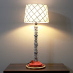 Table lamp with a decorative shade on a wooden surface against a plain wall