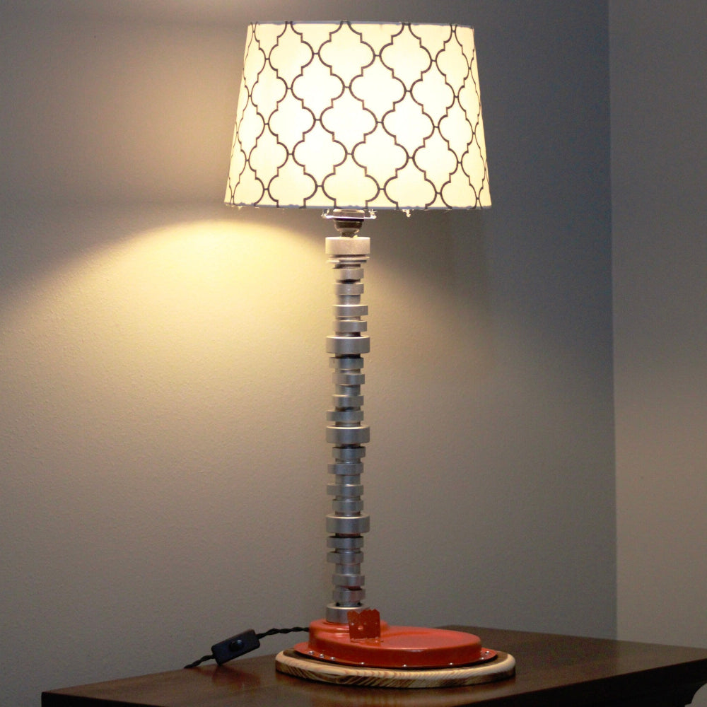 Table lamp with a unique design on a wooden surface against a gray wall