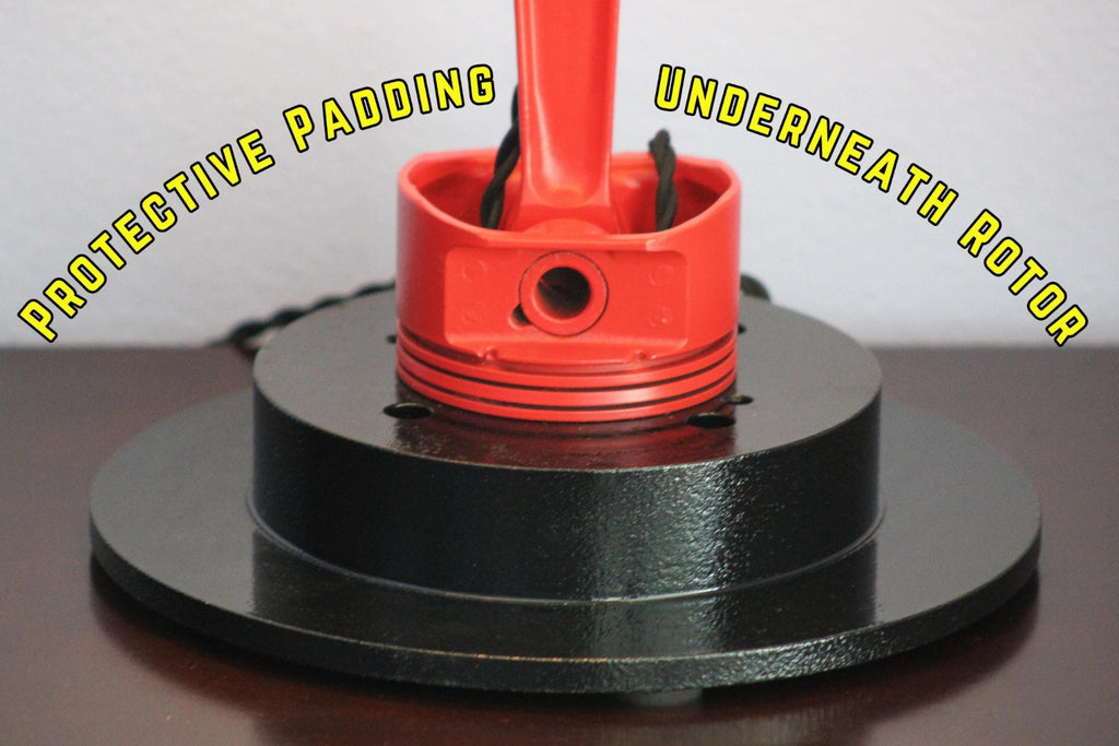 Red rotor with protective padding on a black base against a white background