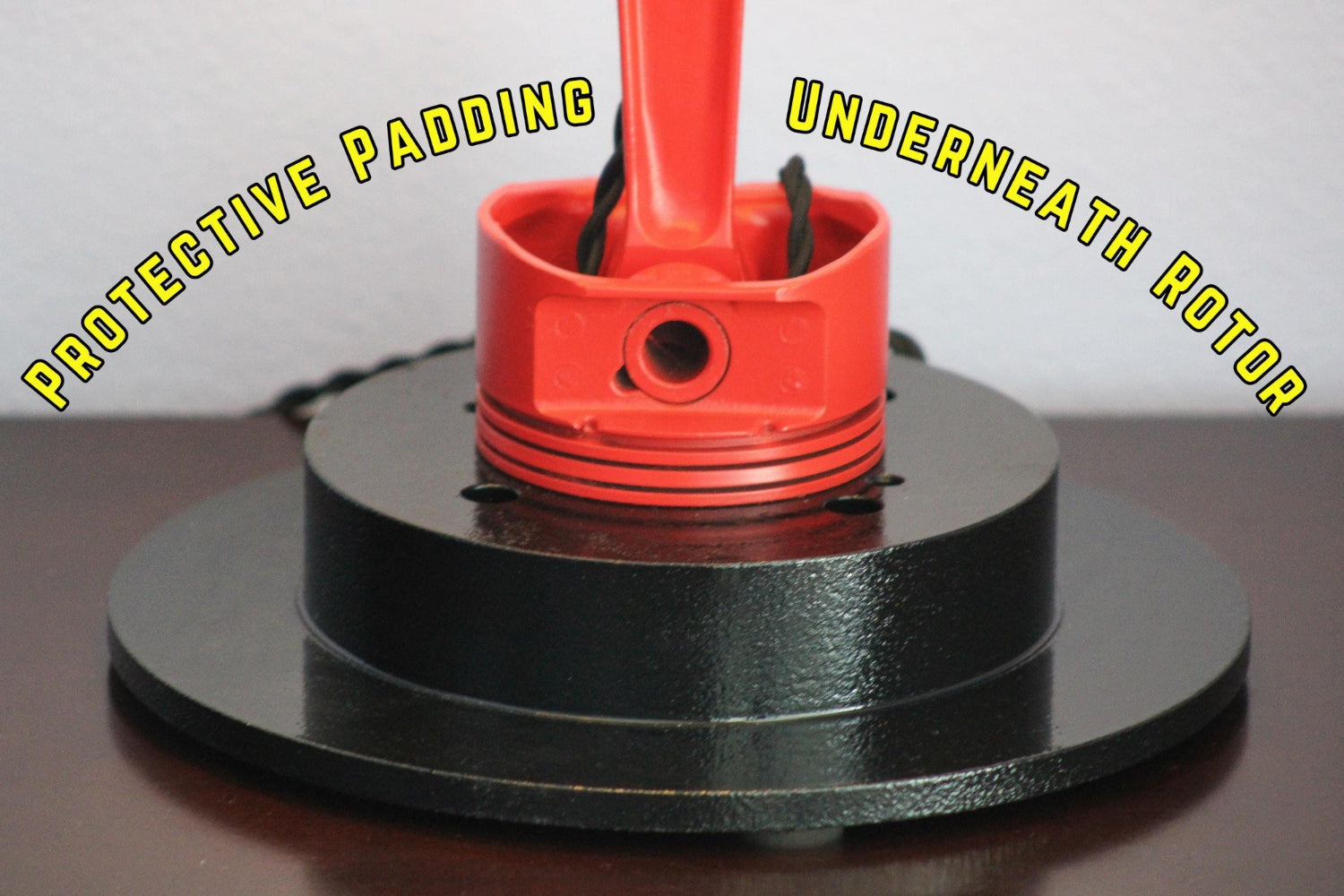 Red rotor with protective padding on a black base against a white background