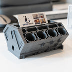 Gray engine block-shaped holder with business cards on a desk