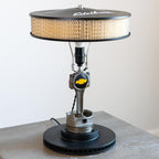 Repurposed air filter lamp on a concrete surface with a white background