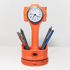 Orange clock-shaped pen holder with a clock face and pens on a white background