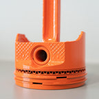 Orange plastic component on a light gray background