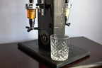 Beverage dispenser with two taps and a glass underneath on a wooden surface.