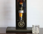 Black Daniel's whiskey decanter with a glass on a wooden surface